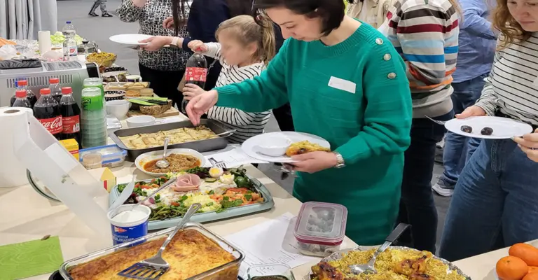 Mitbring-Buffet beim Intercultural Potluck Dinner am OWYO CAMPUS Dresden: eine lange Tafel mit internationalen Speisen aus verschiedenen Kulturen, Symbol für Vielfalt und Austausch.
