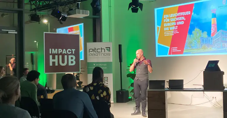 Jacob Romankiewicz vom OWYO CAMPUS präsentiert sein Projekt bei der Pitch Party im Impact Hub Dresden vor Publikum. Rückmeldungen aus dem Publikum fördern den Austausch und die Weiterentwicklung der Idee.